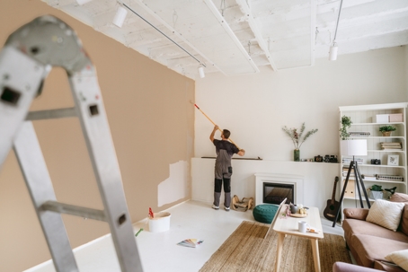 Man painting living room wall.